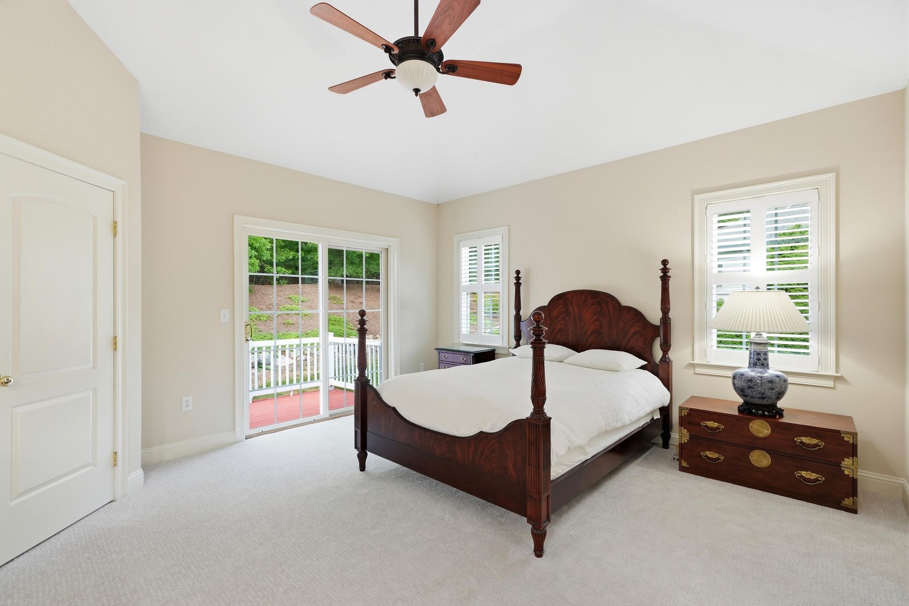 Primary bedroom with vaulted ceiling and slider to the deck