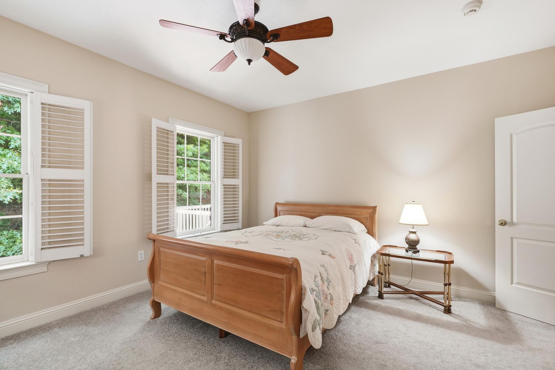 Guest bedroom with sleigh bed and plantation shutters