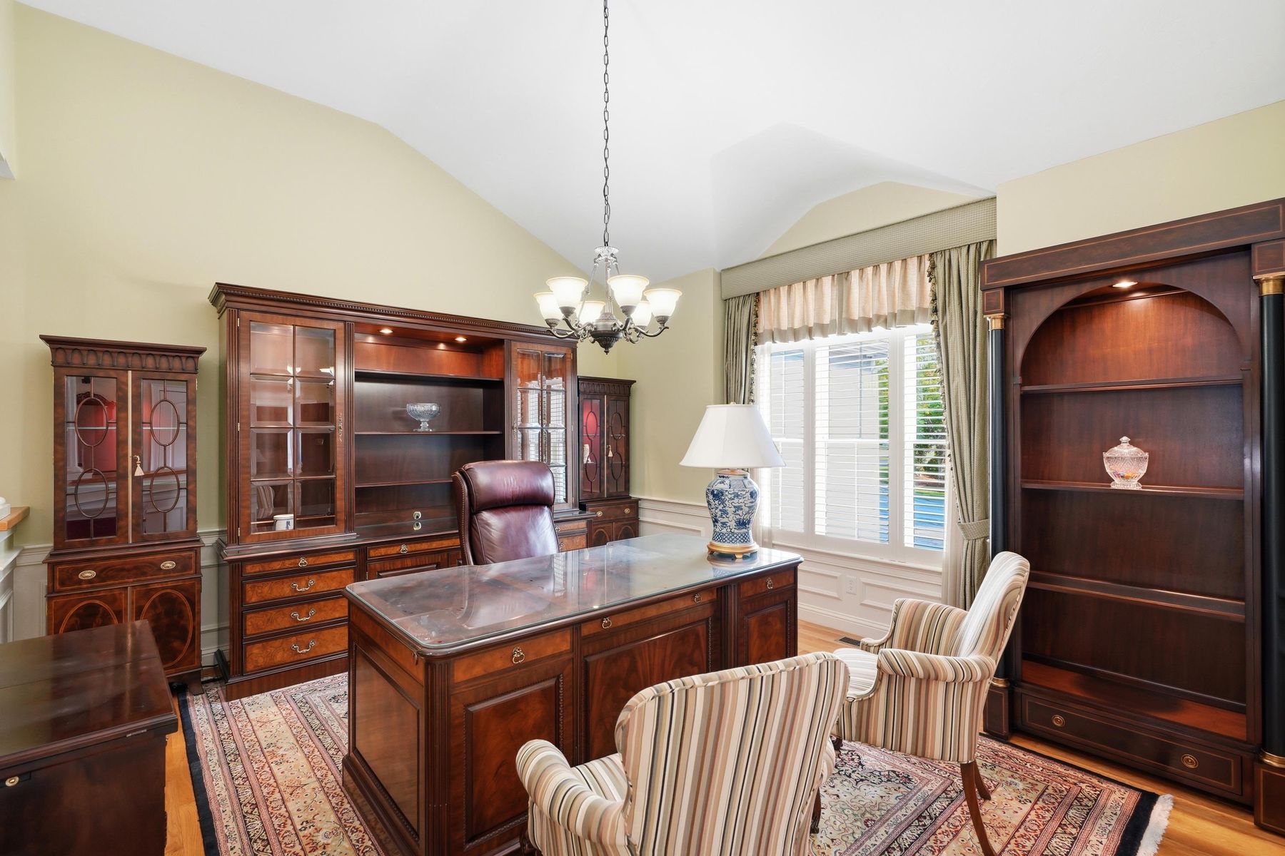 Home office with built-in cabinetry and chandelier