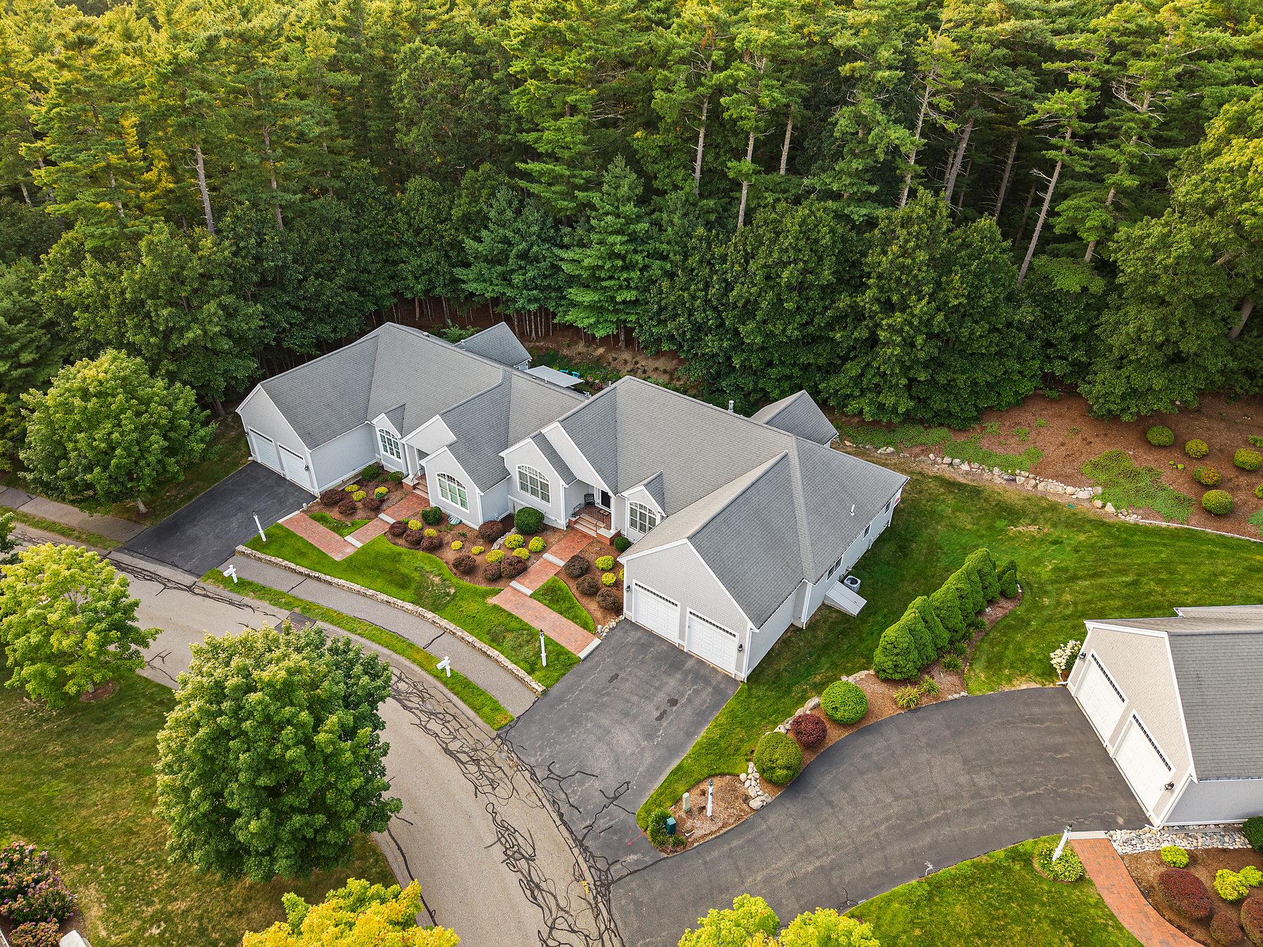 Aerial view of the home, lawn and wooded backyard