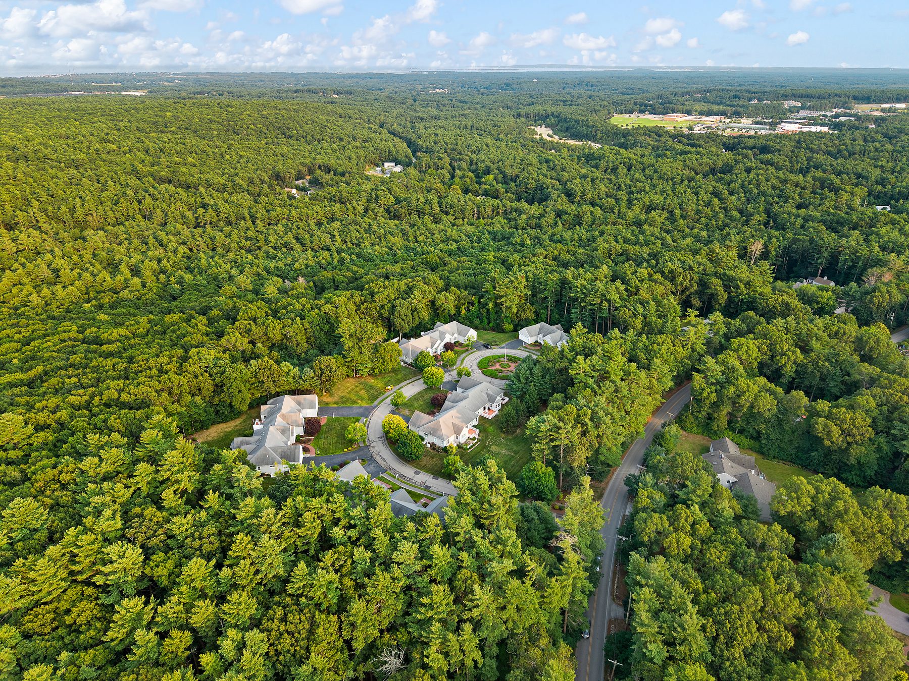Sweeping drone view over Overlook Farm's tree-lined setting
